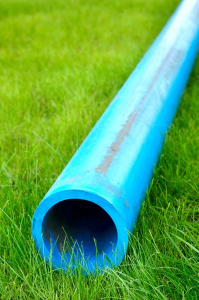 Harmless polyethylene water pipes on a green grass — Stock Photo, Image