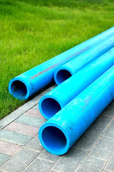 Harmless polyethylene water pipes on a green grass — Stock Photo, Image