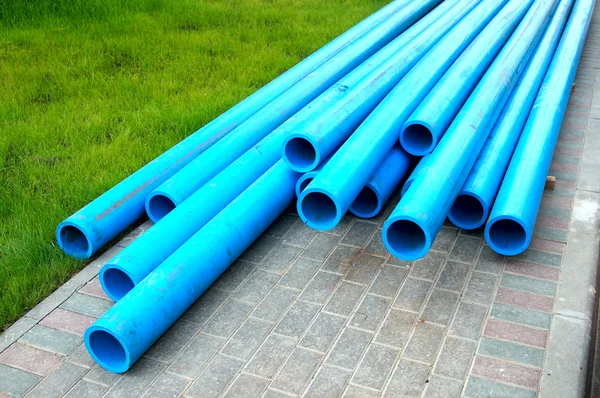 Harmless polyethylene water pipes on a green grass — Stock Photo, Image