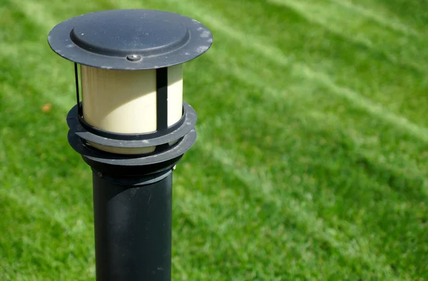 Садовая лампа на зеленой траве — стоковое фото
