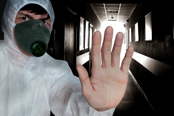 De man in beschermende overalls en gasmasker vertoont een biologische of radioactief gevaar — Stockfoto