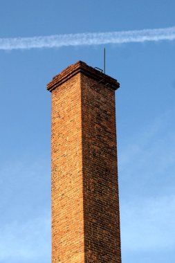 Mavi gökyüzüne karşı tuğla boru.