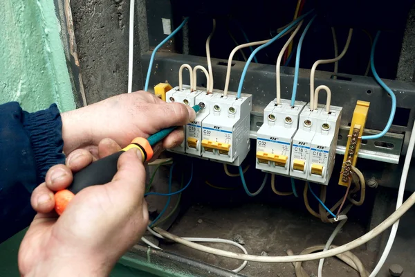 Electric repairs an electric switch — Stock Photo, Image