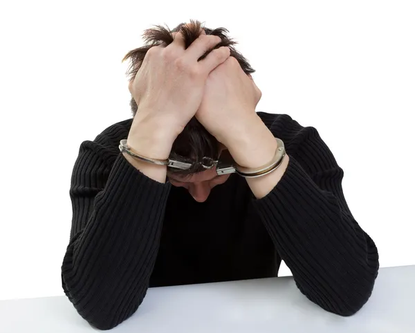 The man in handcuffs closes hands the head. — Stock Photo, Image