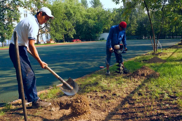 Рабочие копают ямы для забора — стоковое фото