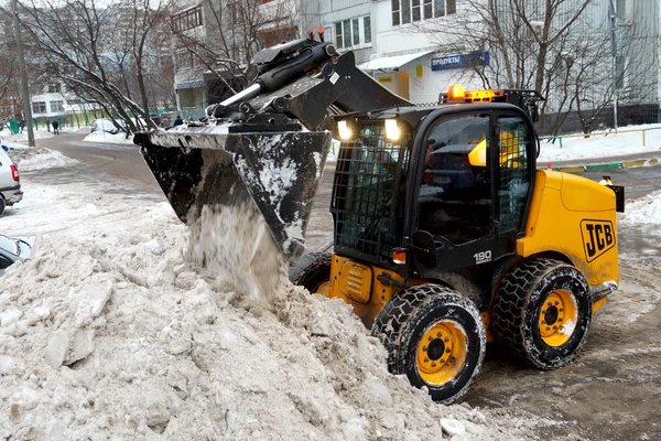 Ciągnik usuwa śnieg na ulicy miasta — Zdjęcie stockowe