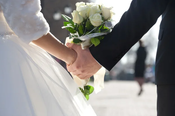 Thème de mariage, tenant les mains jeunes mariés — Photo