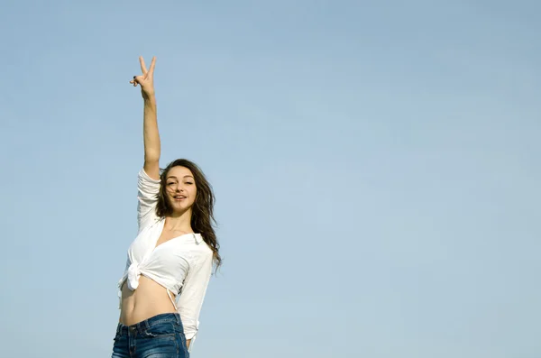 Счастливая взволнованная молодая женщина показывает знак победы . — стоковое фото