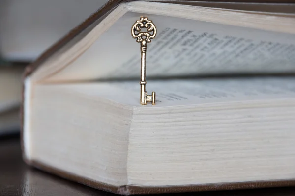 Golden key and a book — Stock Photo, Image