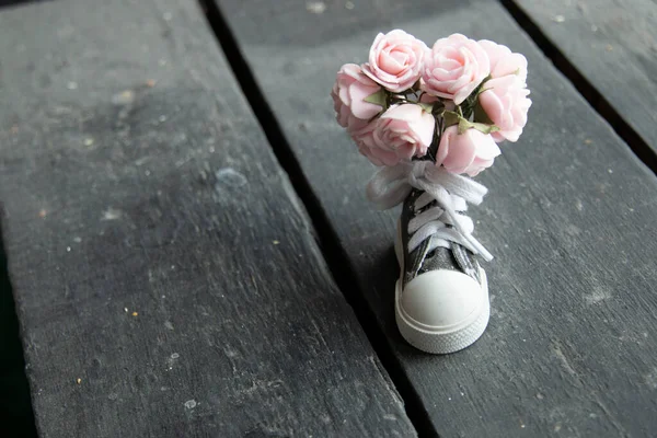 Flores, fondo. Un hermoso ramo de flores y una zapatilla de deporte. — Foto de Stock