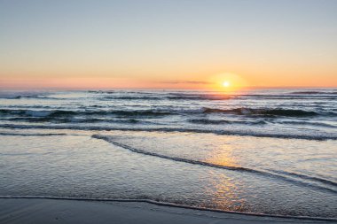 Atlantik Okyanusu üzerinde gün batımı Fransa 'daki Kaptan Ferret' te kumlu bir sahilde..