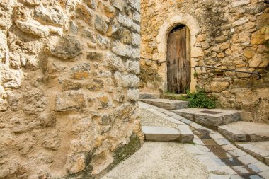 Saint Guilhem le Desert 'deki bir evin ahşap kapısı bir merdiven sokağında yer almaktadır.