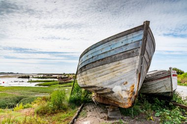 Noirmoutier tekne mezarlığı. Eski ahşap bir balıkçı teknesinin pruvası bulutlu bir gökyüzünün altında duruyor.