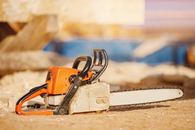 Ahşap evlerin inşaat alanındaki testereler talaş arkaplanında yatıyor.