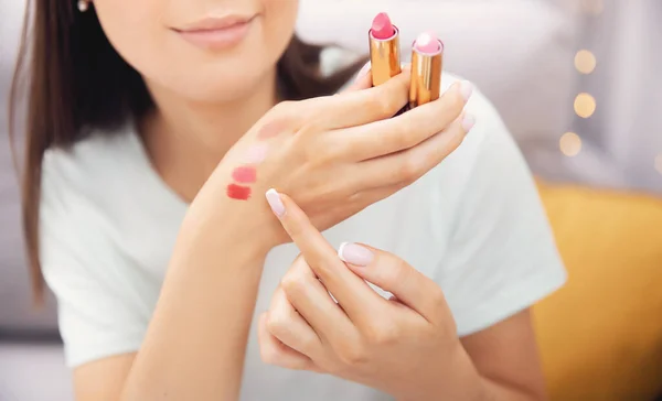 Happy woman beauty blogger is is review cosmetics product is choose new lipstick applies colour on skin of hand — Stok Foto