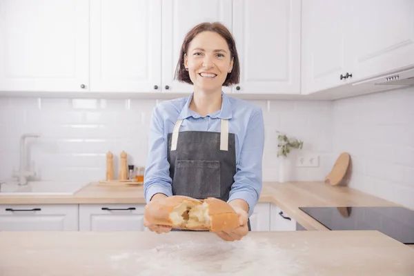 Mãos Baker quebrar quente pão de trigo redondo fresco em duas metades, crunch e migalhas — Fotografia de Stock