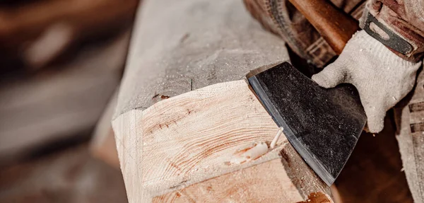 Banner primer plano Carpintero con hacha de trabajo con madera de tronco. Trabajos de carpintería, construcción de casas —  Fotos de Stock