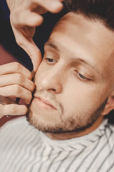 Barbiere rimuove i capelli dopo la rasatura con la spazzola per il viso, parrucchiere maschile — Foto Stock