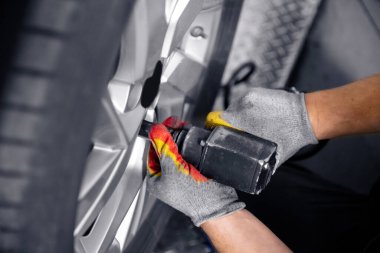 Otomobil tamircisinin ellerini arabanın tekerleklerini sök, üst görünüm