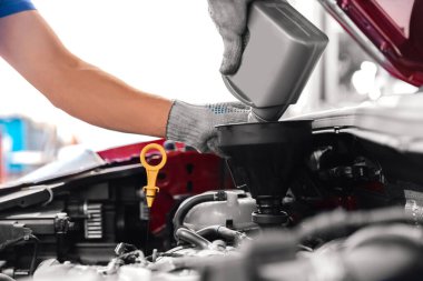 Tamirci atölye garajında kontrol ve servis arabası, motor yağı değişimi üzerinde çalışıyor.