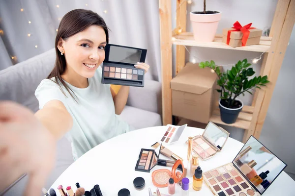 Feliz vlogger mujer está mostrando productos de cosméticos mientras que la grabación de flujo de vídeo en el teléfono. Concepto Influencer blogger beauty blog —  Fotos de Stock