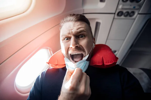 Begreppet aerofobi eller aviofobi. Rädd för rädsla flyger på flygplan och höjd turist man i säker medicinsk mask — Stockfoto