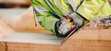 Endüstriyel marangoz elektrikli eklemli kütük öğütüyor, ahşaptan yapılmış inşaat iskeleti şantiyesi