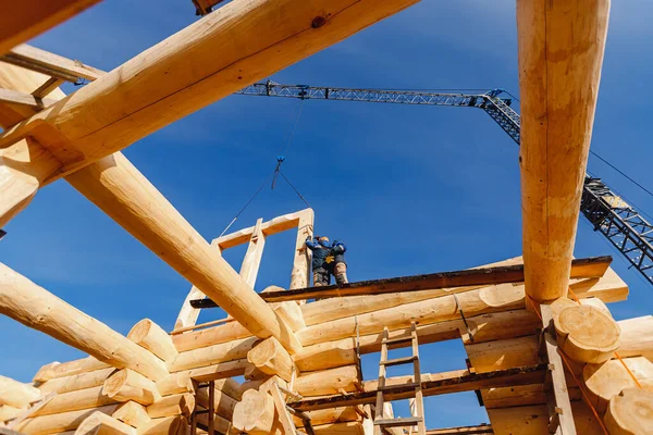 Trabalhador carpinteiro construtor trabalhando na casa do telhado de estrutura de log fundo céu azul — Fotografia de Stock