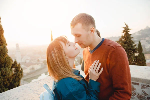 Romantische Paar Mann und Mädchen umarmen und küssen sich auf Sonnenuntergang Hintergrund der Stadt Verona Italien. Reisekonzept — Stockfoto