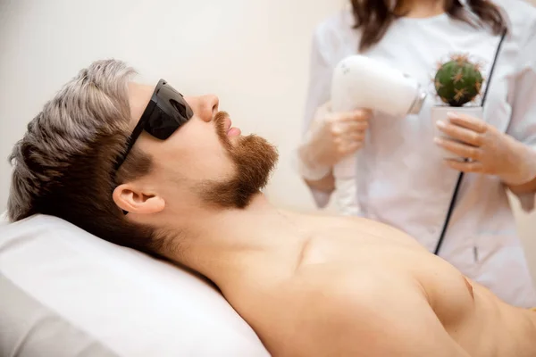 Concetto procedura epilation capelli laser per l'uomo, beauty worker tiene cactus spinoso in mano — Foto Stock