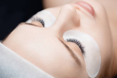 Kirpik uzatma prosedürü. Kadın taraklar 2d kırbaçlandı