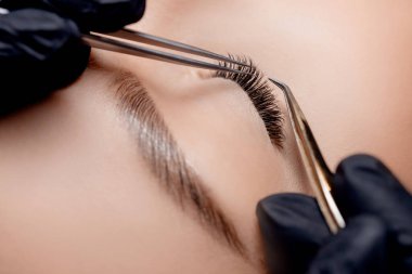 Kirpik uzatma prosedürü. Üstad cımbız siyah sahte uzun kirpikleri güzel bayan gözleri