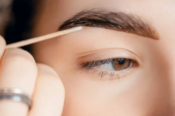 Correção e hena de matiz de sobrancelhas, mestre aplica escova para marcação de mulher na sobrancelha — Fotografia de Stock