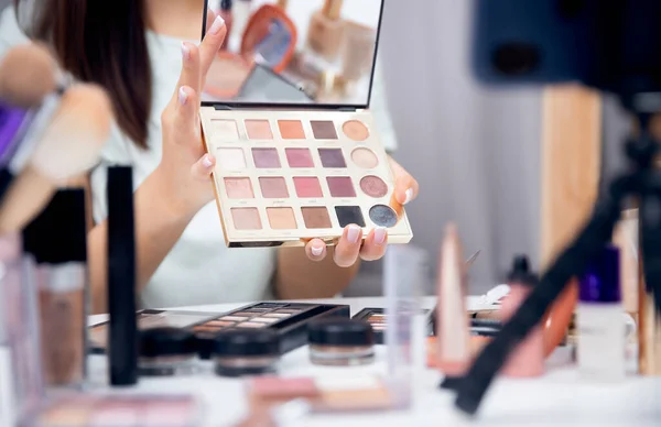 Concepto Influencer blogger beauty blog. Vlogger mujer feliz está mostrando productos de cosméticos mientras que la grabación de flujo de vídeo en el teléfono —  Fotos de Stock