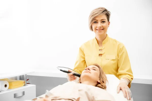 Kobieta otrzymywać pielęgnacji twarzy odmłodzenie z rf podnoszenia aparatury elektrycznej profesjonalny salon piękności, widok z góry — Zdjęcie stockowe