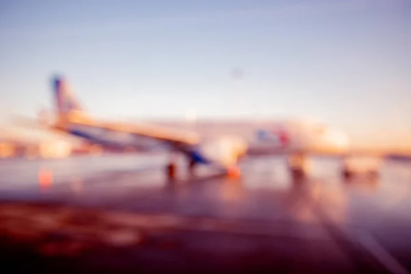 Fondo de desenfoque abstracto del aeropuerto de avión contra la luz solar esperando a los pasajeros — Foto de Stock