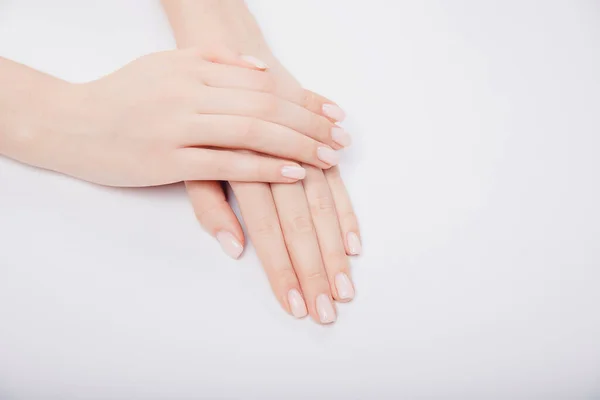 Elegante moderno prego jovem mulher mãos rosa manicure no fundo branco, vista superior — Fotografia de Stock