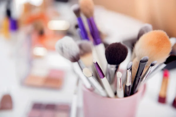 Cepillos de maquillaje kit cosmético de primer plano en taza rosa, espacio de copia de fondo blanco —  Fotos de Stock