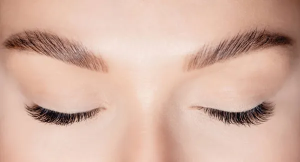 Woman eye with beauty black lashes. Eyelash extension procedure top view — Stock Photo, Image