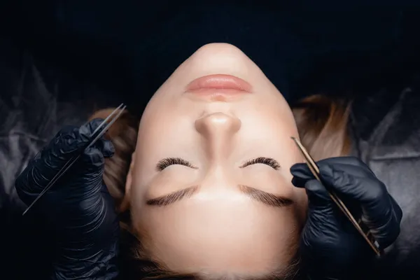 Vista superior del procedimiento de extensión de pestañas. Mujer ojo con belleza negro pestañas —  Fotos de Stock