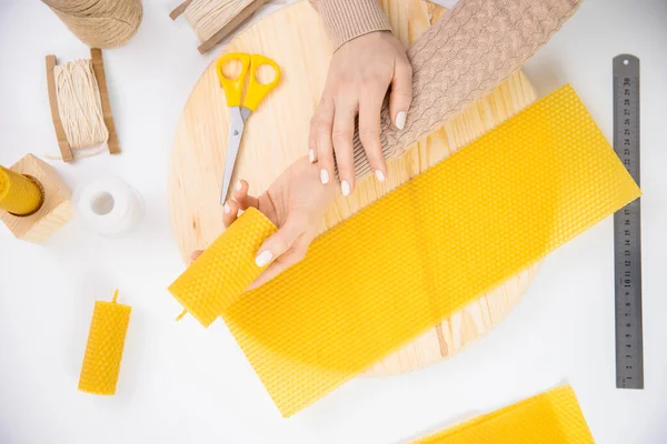 Mujer artesana haciendo velas de cera de abeja amarilla con las manos, vista superior — Foto de Stock