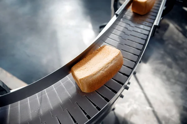 Выпечка квадратный хлеб на конвейере пищевой автоматической линии производства хлебобулочных изделий из горячей печи, вид сверху — стоковое фото