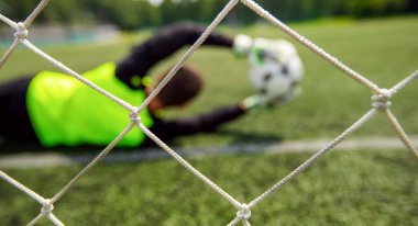 Sancak kalecisi futbolcu topu stadyumda yakalıyor.