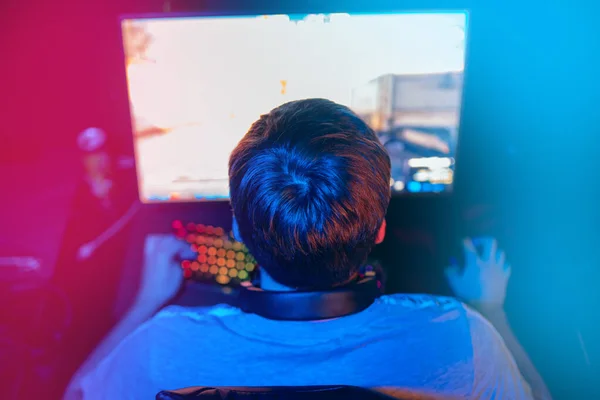 Fondo borroso jugador profesional jugando juegos en línea de campeonato ordenador con auriculares, rojo y azul —  Fotos de Stock