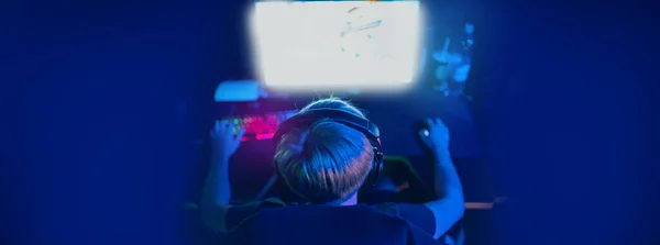 Розмитий фон банер професійний геймер, що грає в турніри онлайн ігри комп'ютер з навушниками, червоний і синій — стокове фото