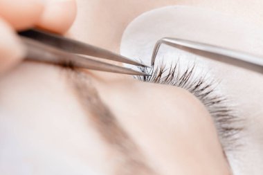 Kirpik uzatma prosedürü. Üstad cımbız sahte siyah kirpikleri güzel bayan gözleri