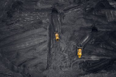 Kömür yükleme, açık bir madende antrasit taşıyan iki sarı kazıcı.