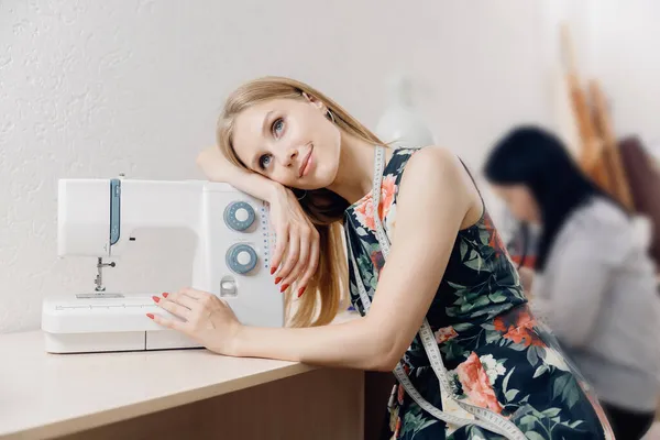 Concept love for sews machine. Portrait of young woman seamstress with measuring tape — Stock Photo, Image
