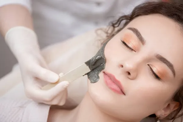 Lekarz stosuje peeling maski dla kobiety stosowania leczenia twarzy na twarzy skóry w salonie piękności spa — Zdjęcie stockowe