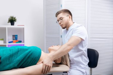 Terapist osteopati, kadın sporcunun omuzlarıyla çalışan spor masajı.